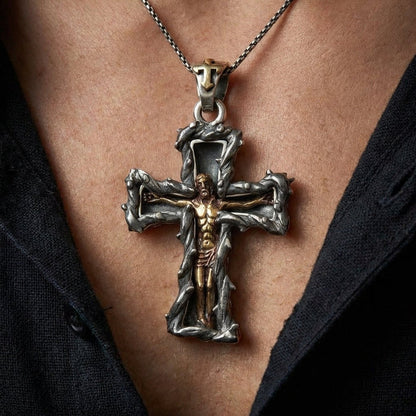 Close-up of handcrafted sterling silver crucifix pendant with golden Jesus figure worn on man's chest