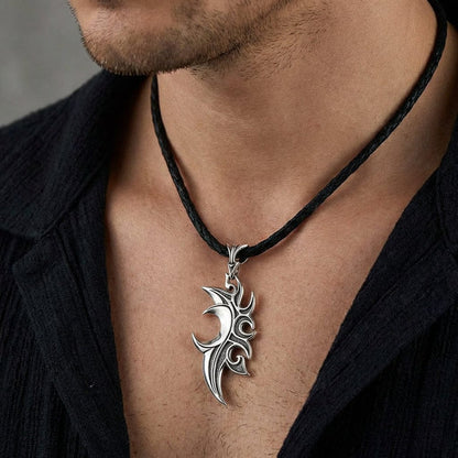 Silver tribal flame pendant with intricate swirling design on black leather cord necklace worn on male chest with open black shirt