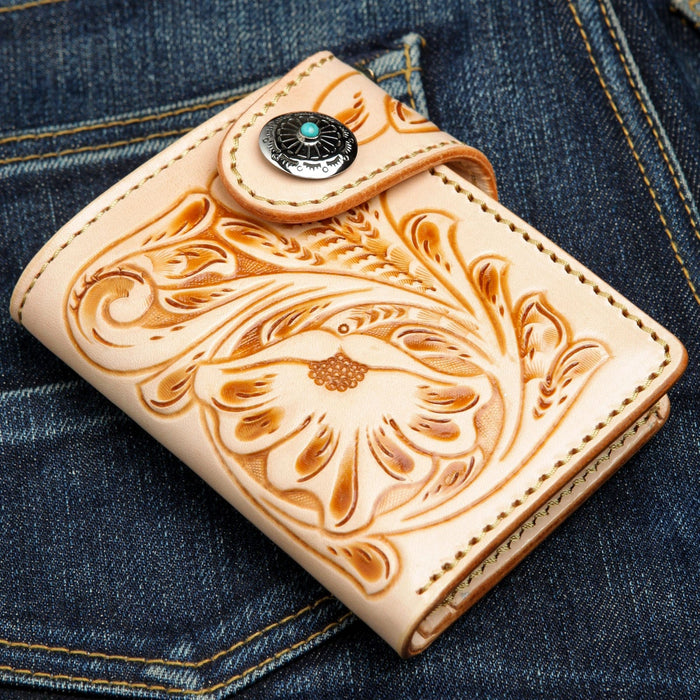 The natural leather short biker wallet shown closed, highlighting the hand-tooled floral pattern.