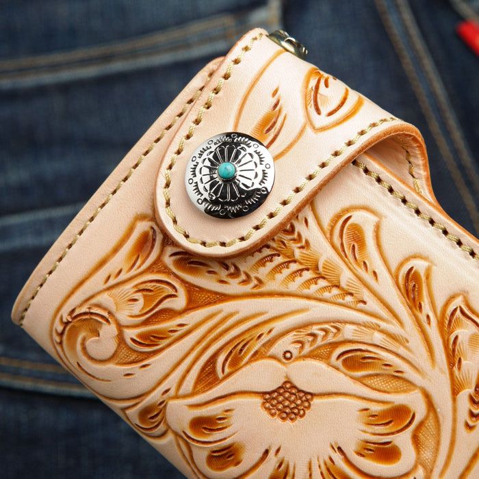 A close-up of the sterling silver and turquoise concho snap on the carved leather wallet.