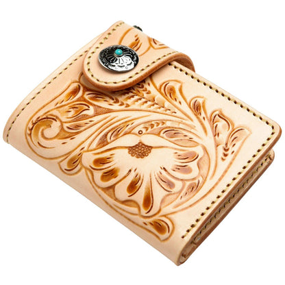 An angled, three-quarters view of the tooled leather wallet with its turquoise concho snap.