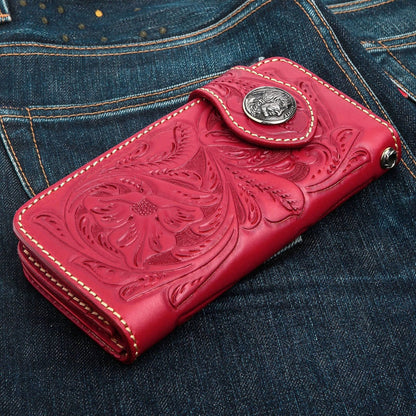 A hand-tooled red American Indian biker wallet with a classic silver concho and deep floral carvings.