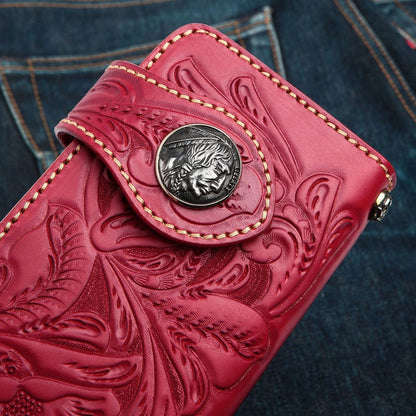 A close-up detail shot of the classic silver Indian Head concho on a vibrant red, hand-tooled leather wallet.