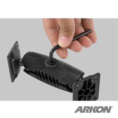 An Allen wrench adjusts a black Heavy-Duty Drill-Base Mount with Security Hardware and AMPS Head, featuring two rectangular plates. The ARKON logo is visible at the bottom right.