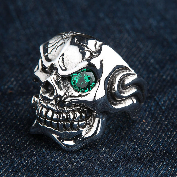 The side view of a polished silver cracked skull ring, showing its substantial band.