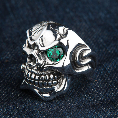 The side view of a polished silver cracked skull ring, showing its substantial band.