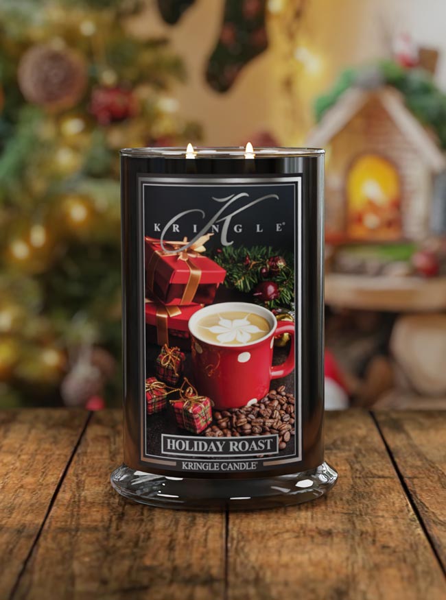 Kringle Candle Holiday Roast candle on a wooden surface with a festive background