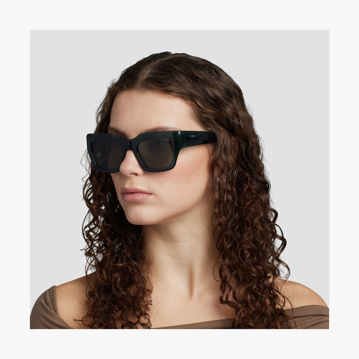 Crystal Emerald / Grey Green Lens | Side view of female model wearing Intrados Sunglasses in Crystal Emerald with Grey Green Lens