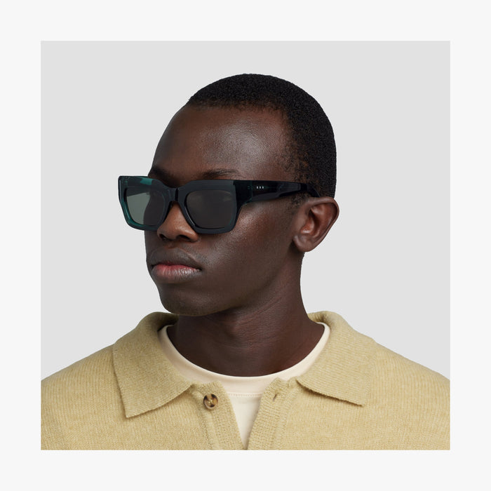 Crystal Emerald / Grey Green Lens | Side view of male model wearing Intrados Sunglasses in Crystal Emerald with Grey Green Lens