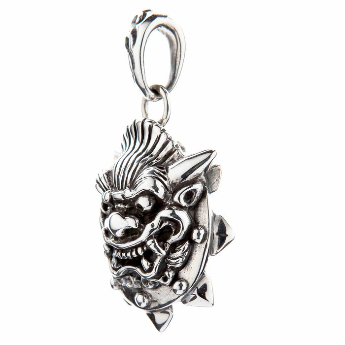 Side view of the oxidized silver Japanese demon pendant showing the bared fangs and spiked edge detail.