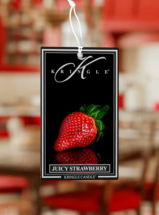 Kringle Candle Juicy Strawberry air freshener tag on a blurred background