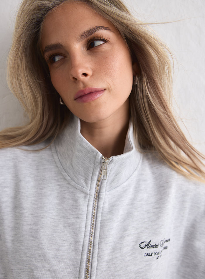 Close-up of a woman wearing a Light Grey Melange Script Zip Jacket from aim'n [M-170cm]