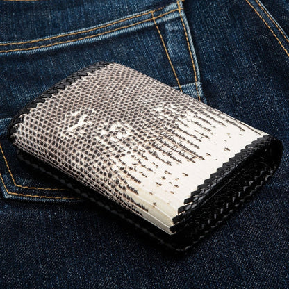 Back of the folded wallet showing the plain lizard skin panel and black braided leather lacing against blue jeans.