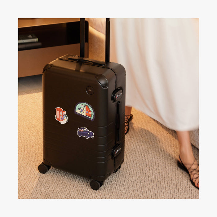 London | All three Destination Stickers of London stickers set on a standing Black suitcase