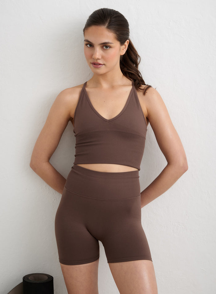Macchiato Shape Seamless Hotpants by aim'n paired with a matching bra against a white wall. [S-178cm]