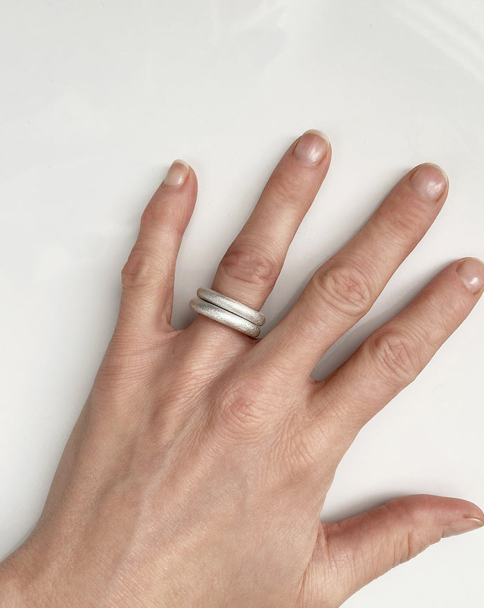 Två tjocka silverringar med matta ytor i en ring stack.
