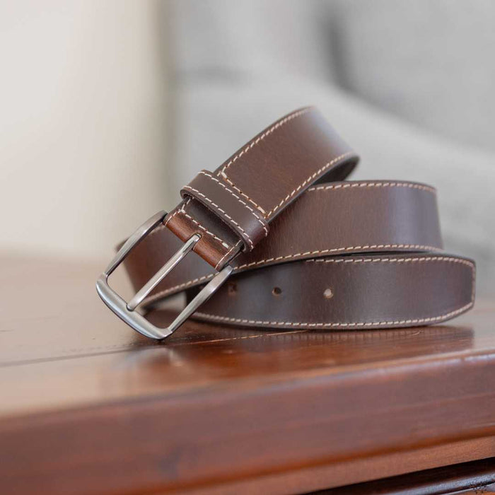Silver nickel free buckle sewn onto medium brown leather with sewn edge of cream colored stitching