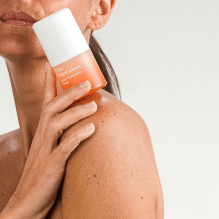 Femme tenant la lotion hydratante MONO – soin visage naturel et efficace pour peau équilibrée