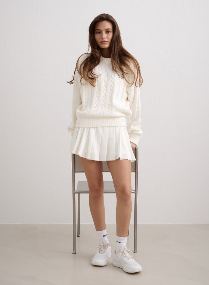 Off-white cotton cable knit sweater by aim'n styled with a white pleated skirt. [M-174cm]