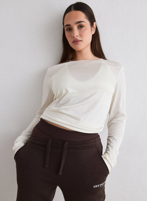 A model wearing an Off White Luminous Draped Long Sleeve paired with brown sweatpants [L-174cm]