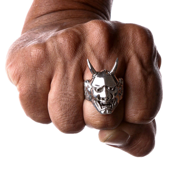 A man's hand wearing the heavy 22-gram Oni mask ring to demonstrate its large, statement size.