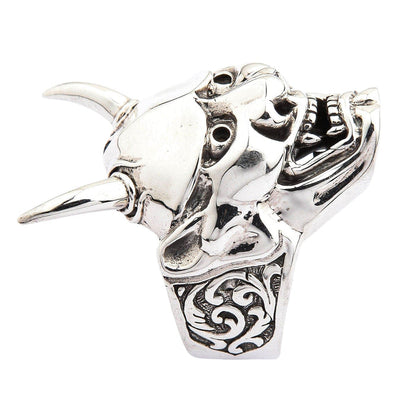 A close-up, angled shot of the Hannya mask ring focusing on the fangs and polished forehead.