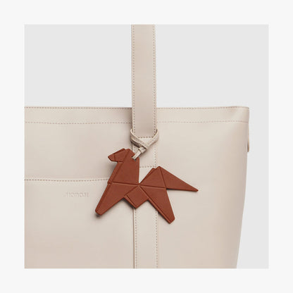 Mahogany | Close-up view of the Origami Horse Charm attached to a Tote bag