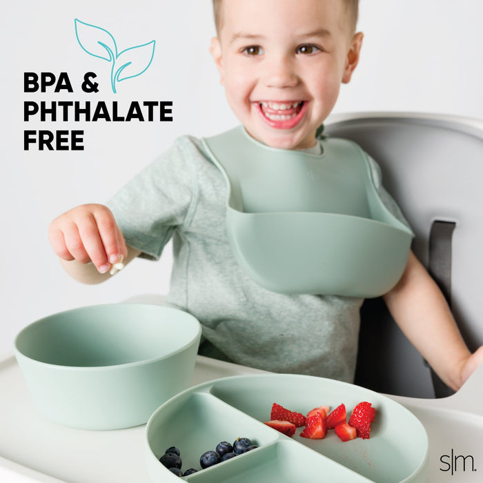 Collection of sage green silicone toddler tableware including plates, bowls, and utensils arranged on a white background, BPA-free dishware set for babies and young children.