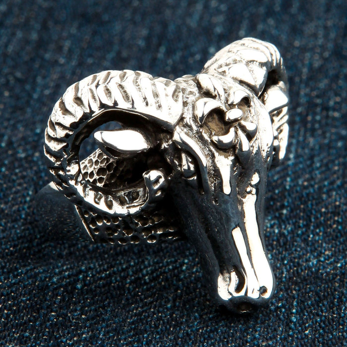 Angled profile highlighting the tight ridges of the curled horn and polished snout of the .925 silver piece.