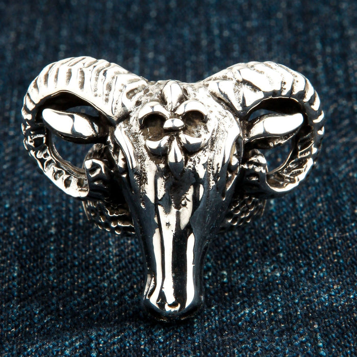 Close-up resting on blue denim, emphasizing the polished snout and intricate crown emblem of the men's silver piece.