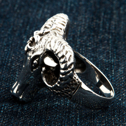 Side perspective showing the deep carvings of the spiraling horn and the textured transition on the solid silver band.