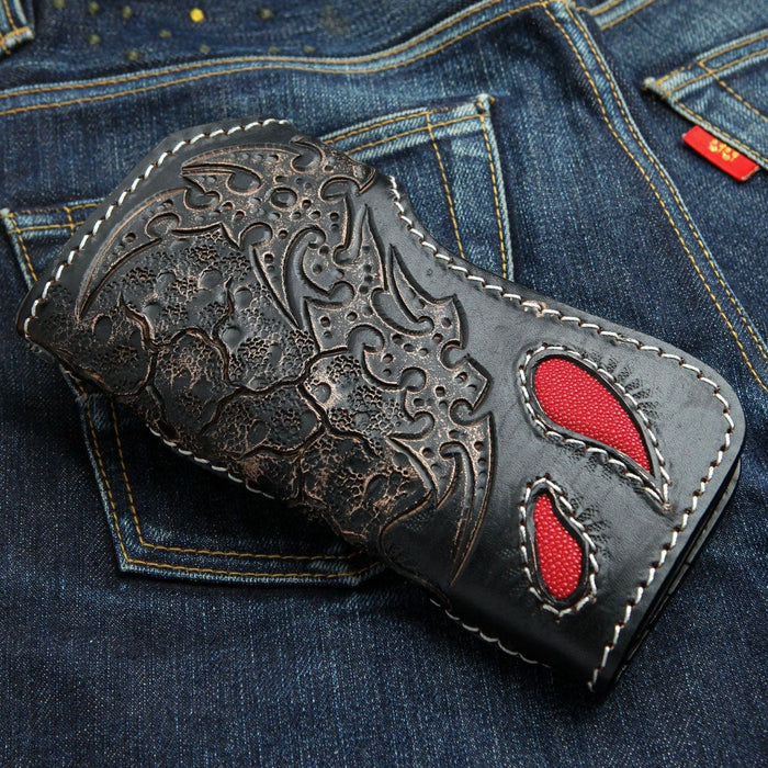 Two teardrop cutouts open onto red stingray beneath the embossed scrollwork, outlined in white stitching.