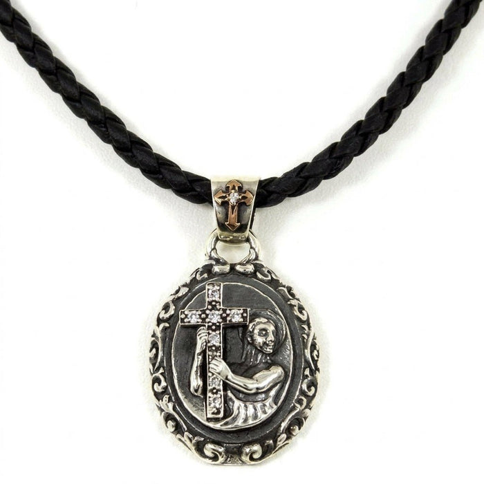 Suspended sterling silver pendant on a black braided cord, displaying the ornate bail and saint holding a CZ cross.
