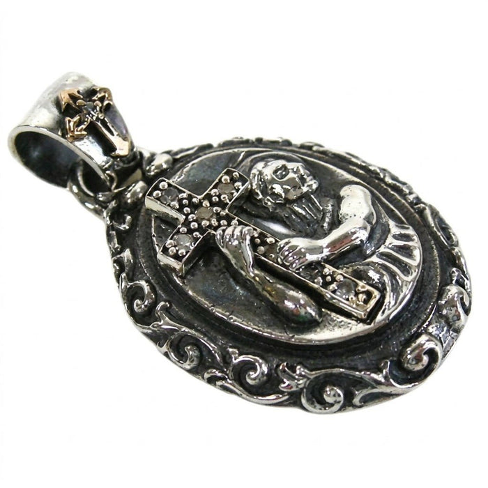 Angled close-up showing the 3D relief of a saint grasping a CZ-lined cross, framed by an ornate oxidized silver border.