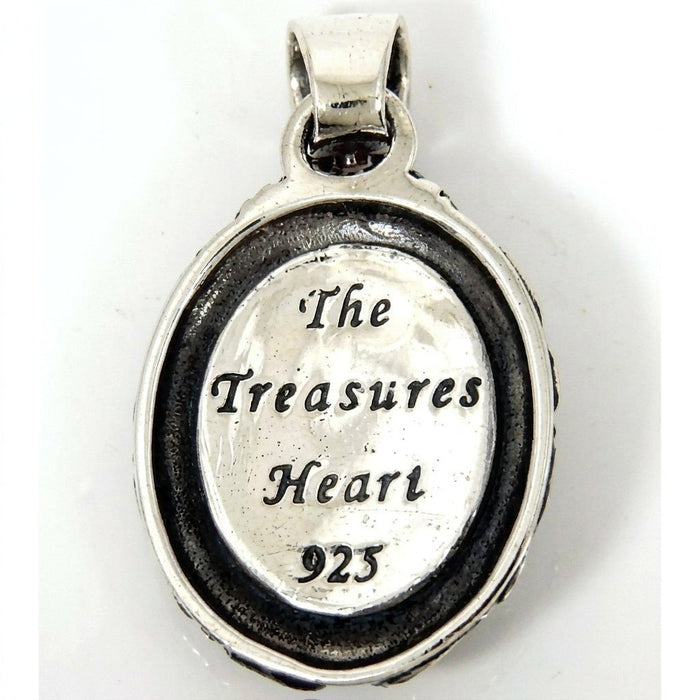 Reverse side of the silver medallion showing 'The Treasures Heart' engraving and a 925 hallmark stamp.