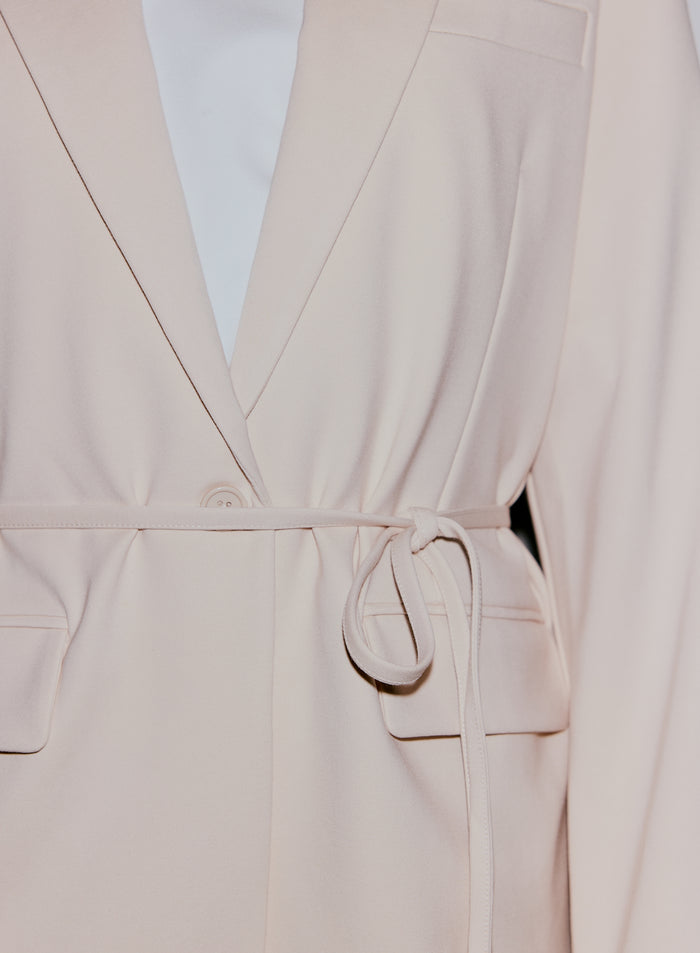 Close-up of a sand Luxe Relaxed Blazer, showing the self-tie belt and front button closure [40-170CM]