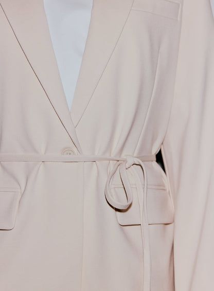 Close-up of a sand Luxe Relaxed Blazer, showing the self-tie belt and front button closure [40-170CM]