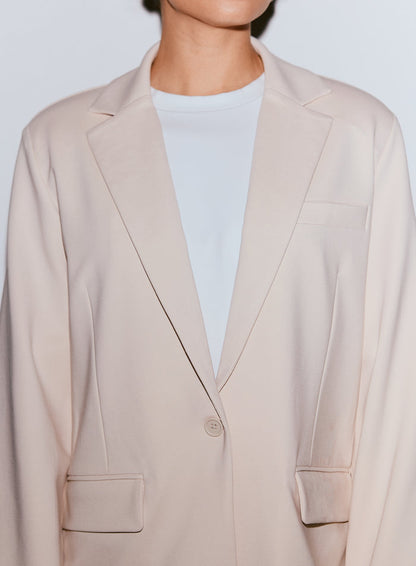 Close-up of a person wearing a sand Luxe Relaxed Blazer over a white t-shirt [40-170CM]