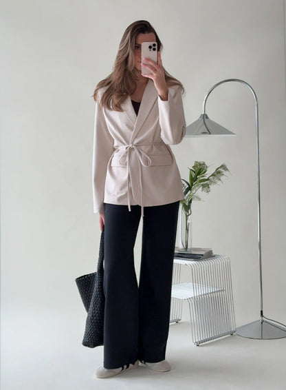 A woman taking a mirror selfie wearing a sand Luxe Relaxed Blazer from aim'n [38-175cm]