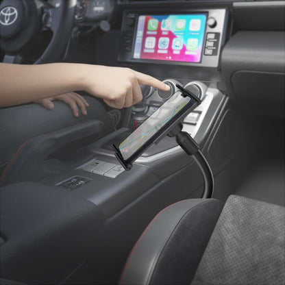 A person interacts with a smartphone secured in a Slim-Grip® Ultra 18″ Seat Rail or Floor Car Mount inside a car, with a navigation map shown on the phone’s screen and the car’s infotainment system visible in the background.