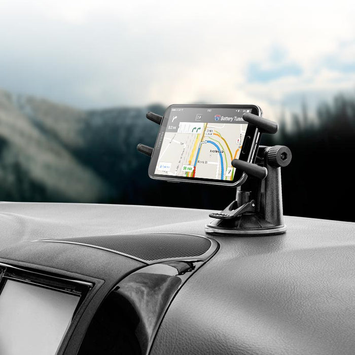 A smartphone with a navigation app is held in the Slim-Grip® Ultra Windshield or Dash Car Mount, featuring a suction base and 360° rotation, attached to a black dashboard with a blurred outdoor background.