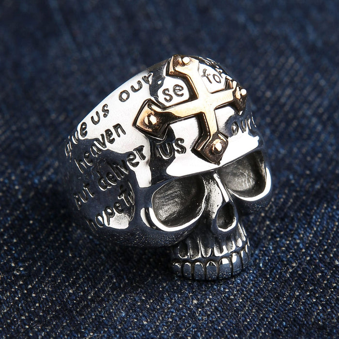An angled view of the two-tone Christian biker ring with a skull and gold cross.