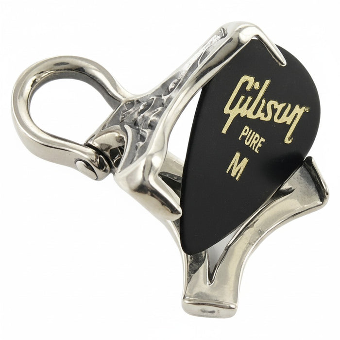 The sterling silver pick holder locket shown open, with a black guitar pick next to it.