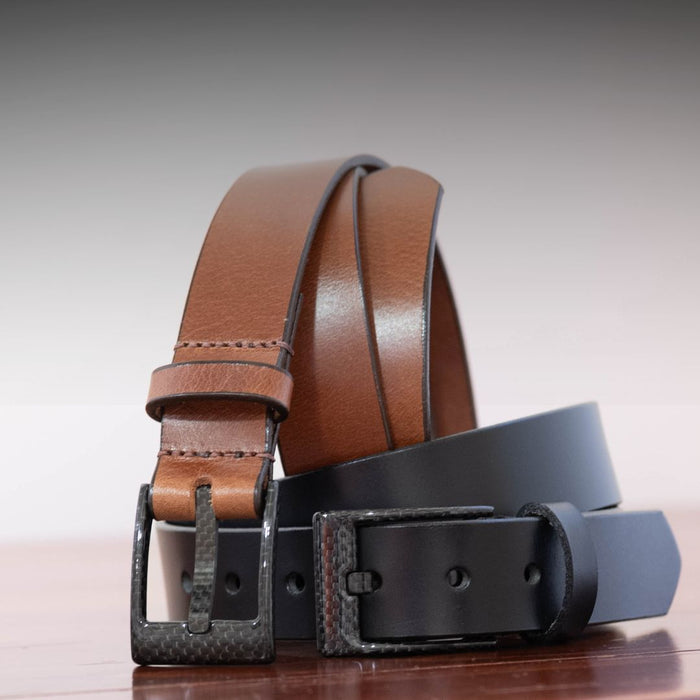 Two belts with the same carbon fiber buckle, one with a black strap, one with a brown.