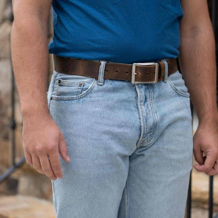 Site Manager Distressed Brown Leather Belt on model wearing blue jeans and blue t-shirt.