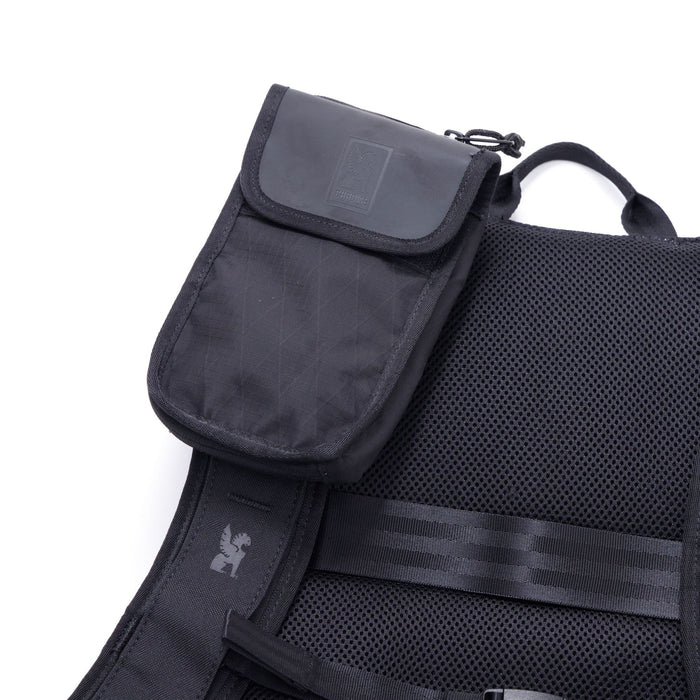 The Travel Tech Pouch in black mounted on a backpack strap
