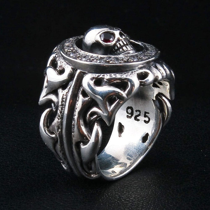 Inner band of the sterling silver skull ring stamped .925, viewed from above with one red garnet eye catching the light.