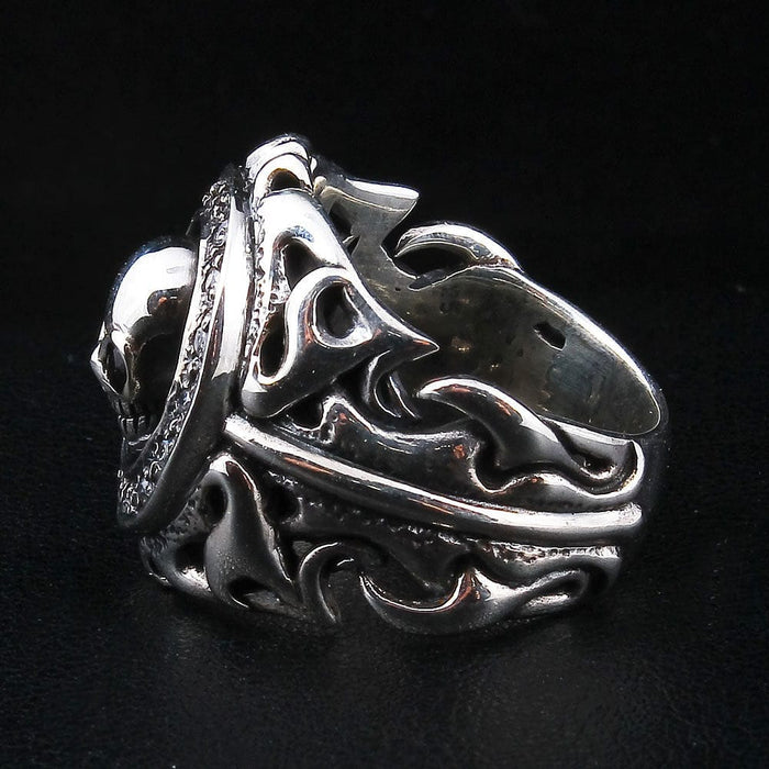 Side profile of the tribal skull ring revealing the thickness and openwork detail of the silver scrollwork shoulders.