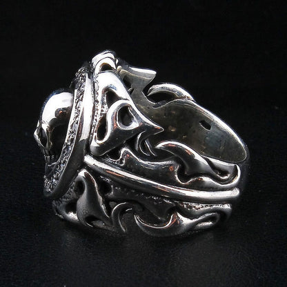 Side profile of the tribal skull ring revealing the thickness and openwork detail of the silver scrollwork shoulders.