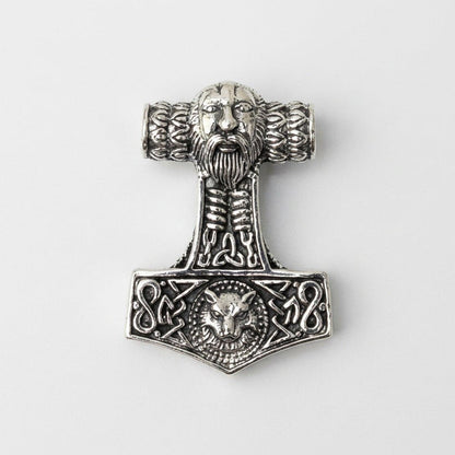 Front view of the sterling silver Mjolnir pendant featuring a bearded face top, knotwork shaft, and Fenrir wolf head base.